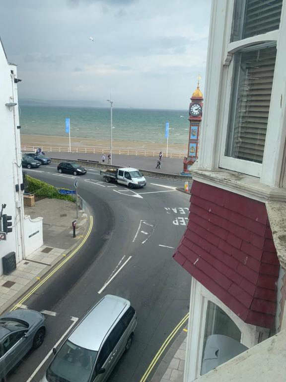 a view from a window of a road with a clock tower at Amazing sea views ,brilliant location Apartment in Weymouth