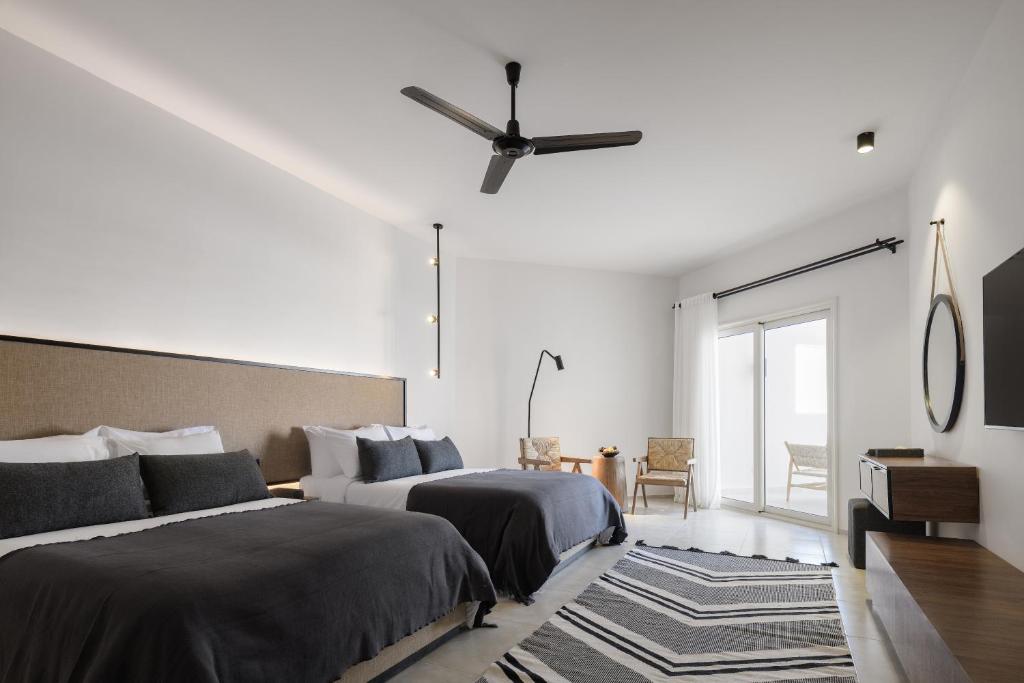 a bedroom with two beds and a ceiling fan at Serry Beach Resort in Hurghada