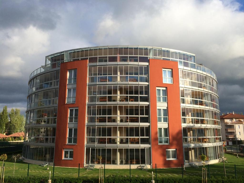 un gran edificio rojo con muchas ventanas en Luxury Hotel Siófok, en Siófok