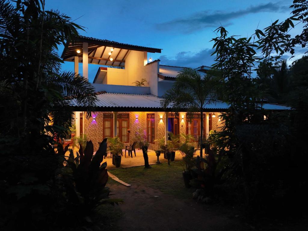 una casa iluminada por la noche con luces en Nature World Jungle Paradise, en Udawalawe