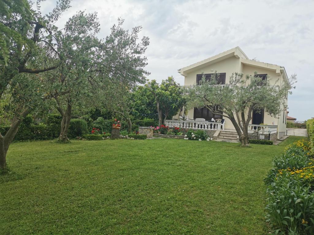 a white house with a lawn in front of it at Home Nicole in Bibinje