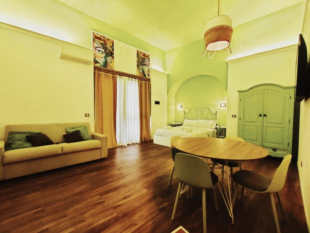 een woonkamer met een tafel en een bed bij CentroCittà Next in Catania