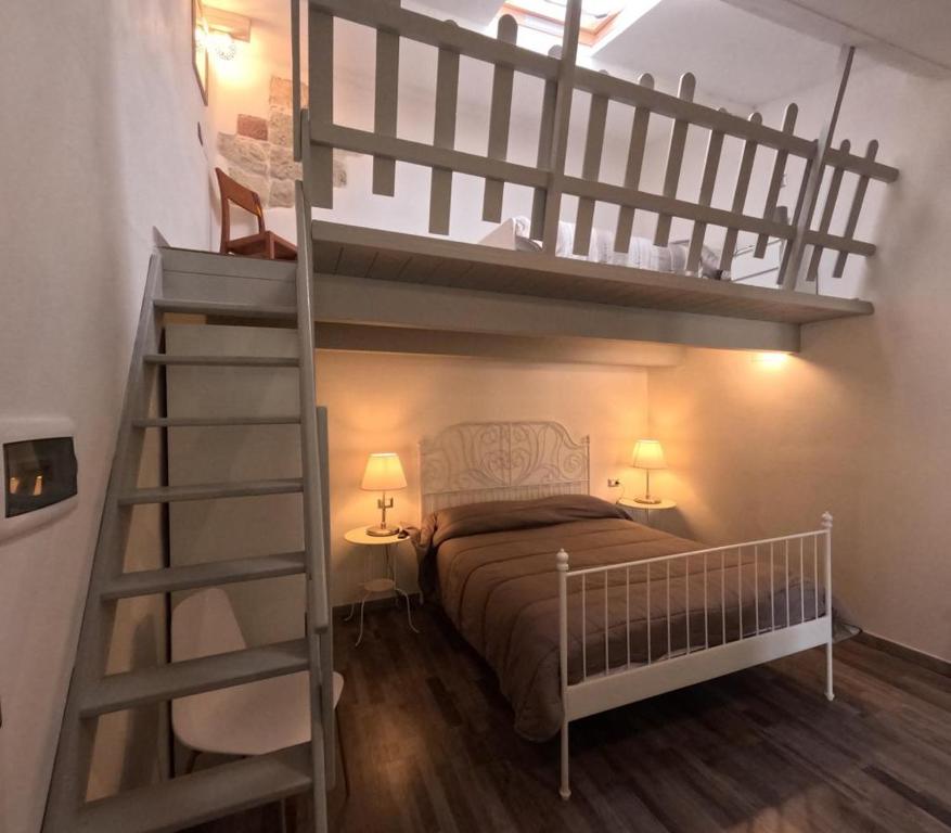 a bedroom with a bunk bed and a ladder at Sole Azzurro Suite in Bosa