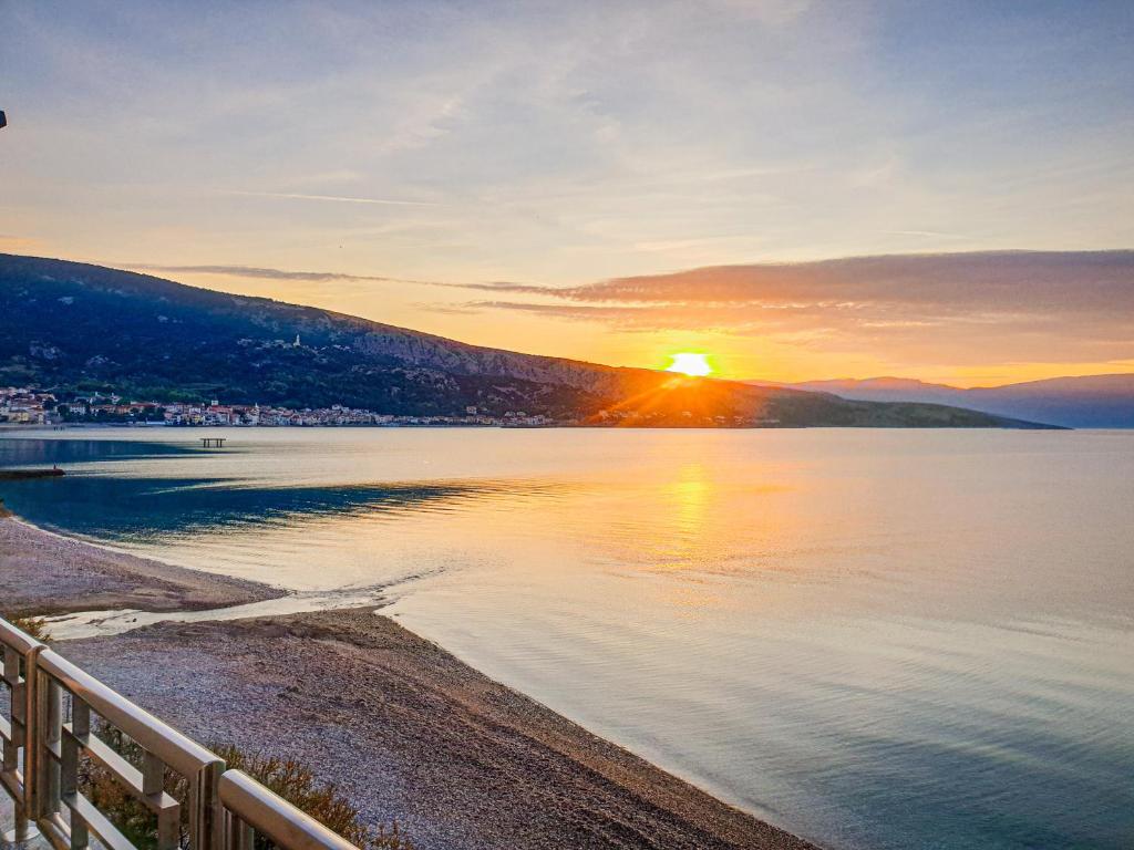 a sunset over a body of water at Hotel Dobrovit in Baška