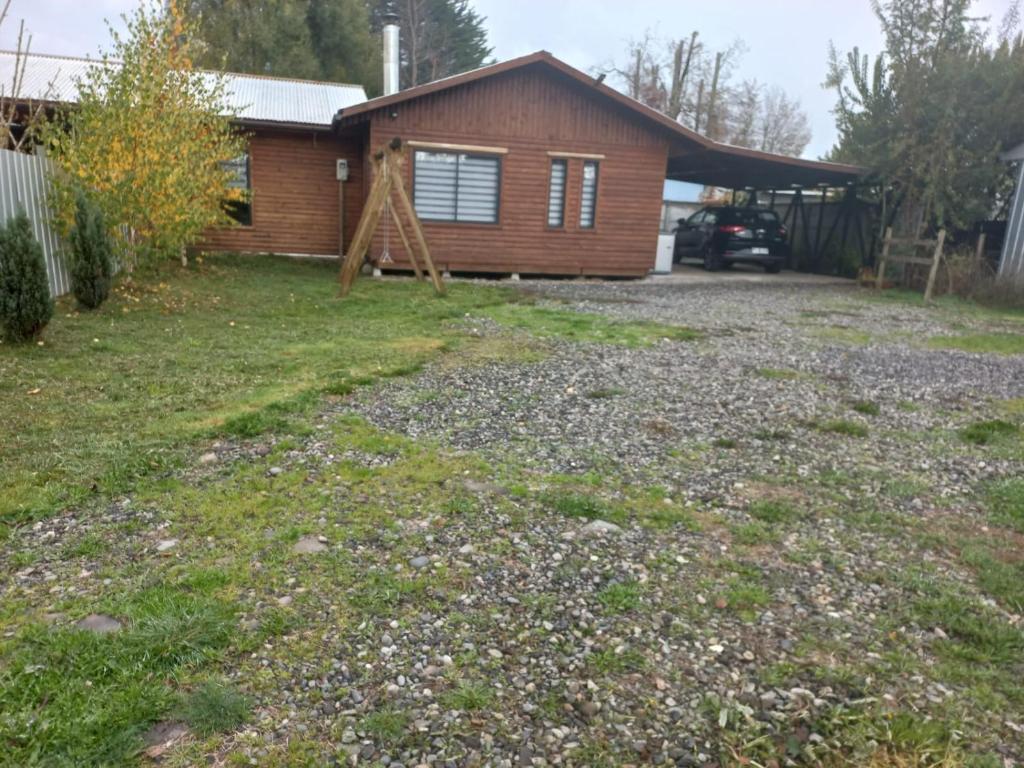 a yard in front of a house at Cabaña Dos Ríos in Villarrica