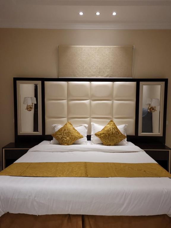 a bedroom with a large white bed with two pillows at لاكازا للشقق المخدومة in Riyadh