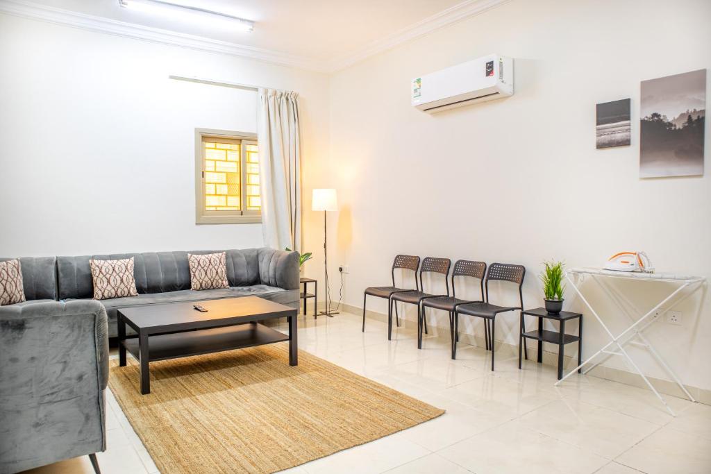 a living room with a couch and a table and chairs at Luxurious Family 3 Bedroom Apartments 10 Mins Drive to Al-Masjid Nabawi - Qaswarah residence in Medina