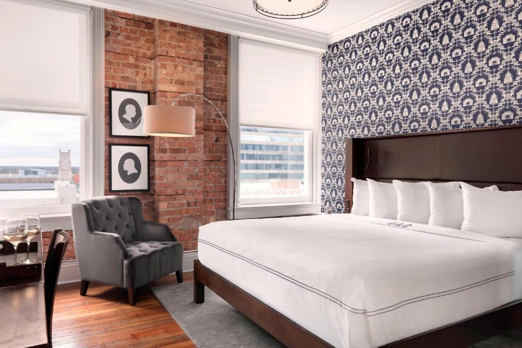 a bedroom with a large bed and a chair at Q&C Hotel and Bar New Orleans, Autograph Collection in New Orleans