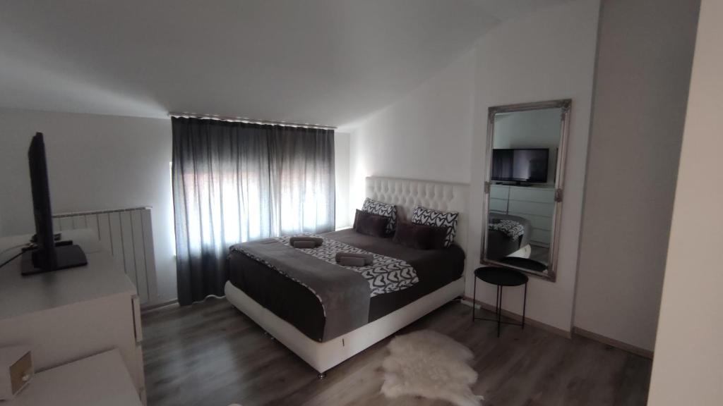 a bedroom with a bed and a large mirror at Villa Mahala in Sarajevo