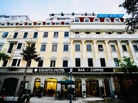 a large white building with a bar cafe in front of it at Lucasta Hotel Ha Long in Ha Long