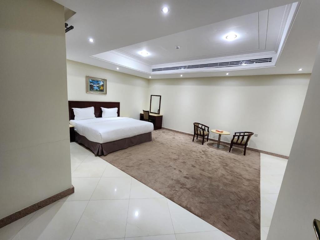 a bedroom with a bed and a table and chairs at S Maskan Hotel in Dammam