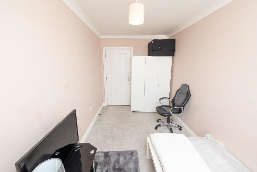 a bedroom with a bed and a desk and a chair at Newly refurbished apartment in Elmers End