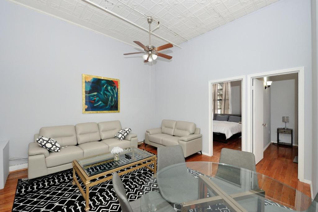 ein Wohnzimmer mit einem Sofa und einem Tisch in der Unterkunft Beautiful 4BR 1Bath in Chamber Street NYC in New York