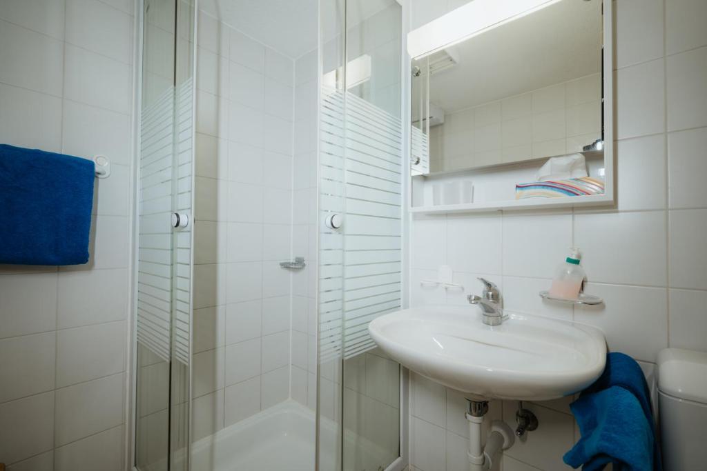 un bagno bianco con lavandino e doccia di Hotel Sonne ad Amden