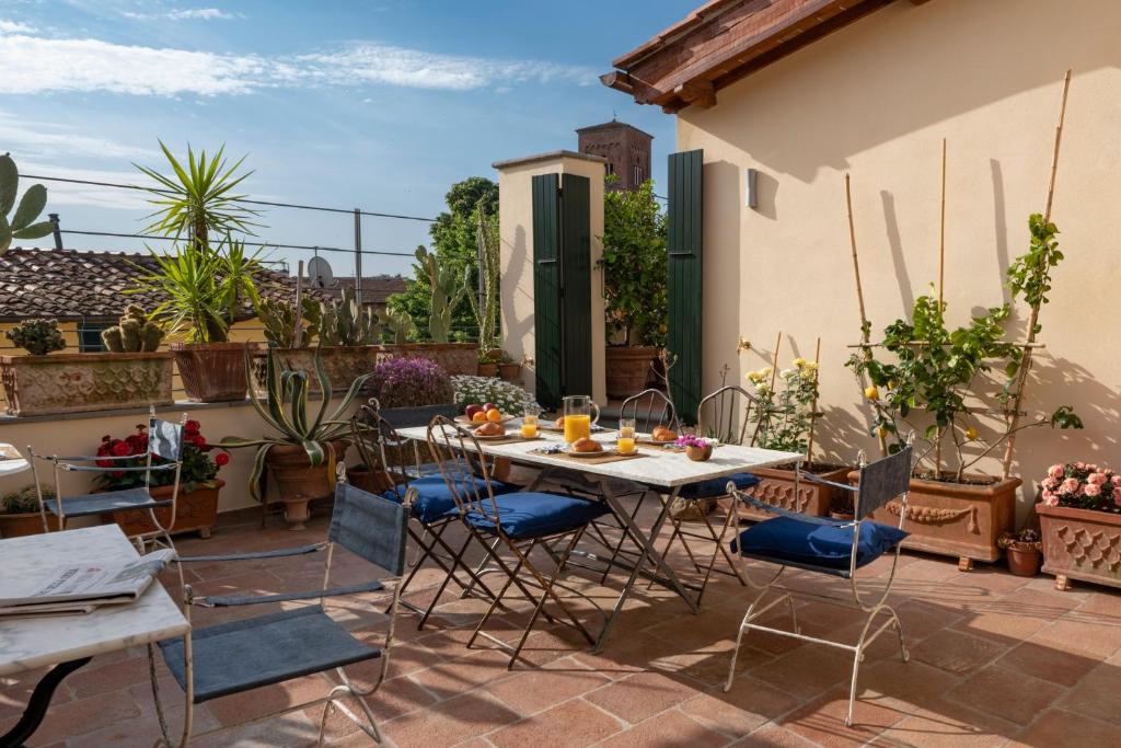 un patio con mesa y sillas en la azotea en My GuestHouse en Lucca