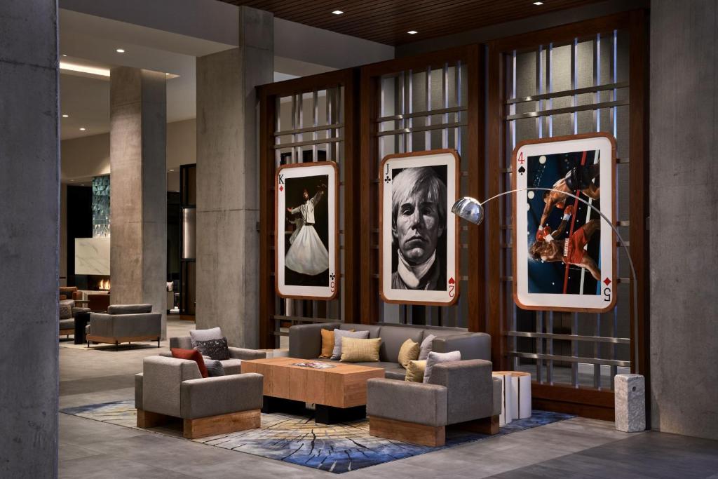 a lobby with couches and portraits on the wall at Marriott Owings Mills Metro Centre in Owings Mills
