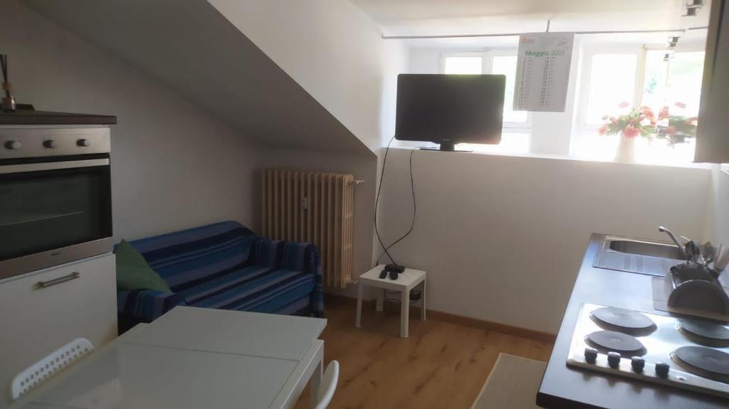 uma pequena sala de estar com um sofá e uma cozinha em Rifugio piemontese em Barge