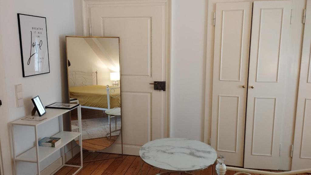 een kamer met een spiegel, een tafel en een kruk bij Stadthaus Zimmer 6 neben dem REM-Museum in Mannheim Mitte in Mannheim