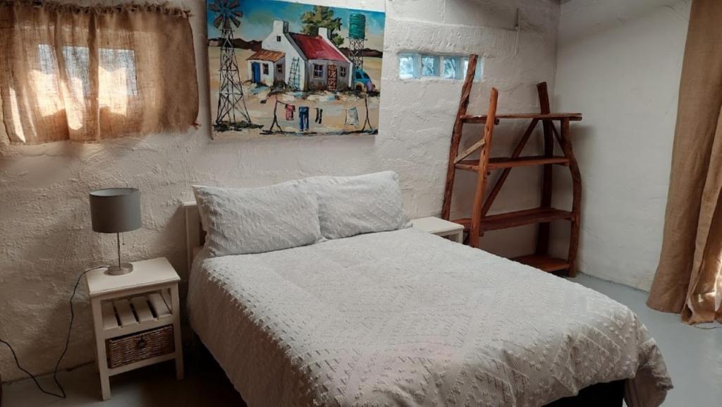 - une chambre avec un lit et une peinture murale dans l'établissement 11 Mountain Stream Hot Tub Self Catering, à Gordons Bay