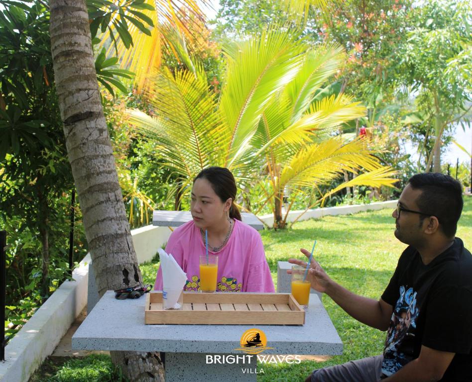 a man and a woman sitting at a table at Bright Waves Villa in Bentota