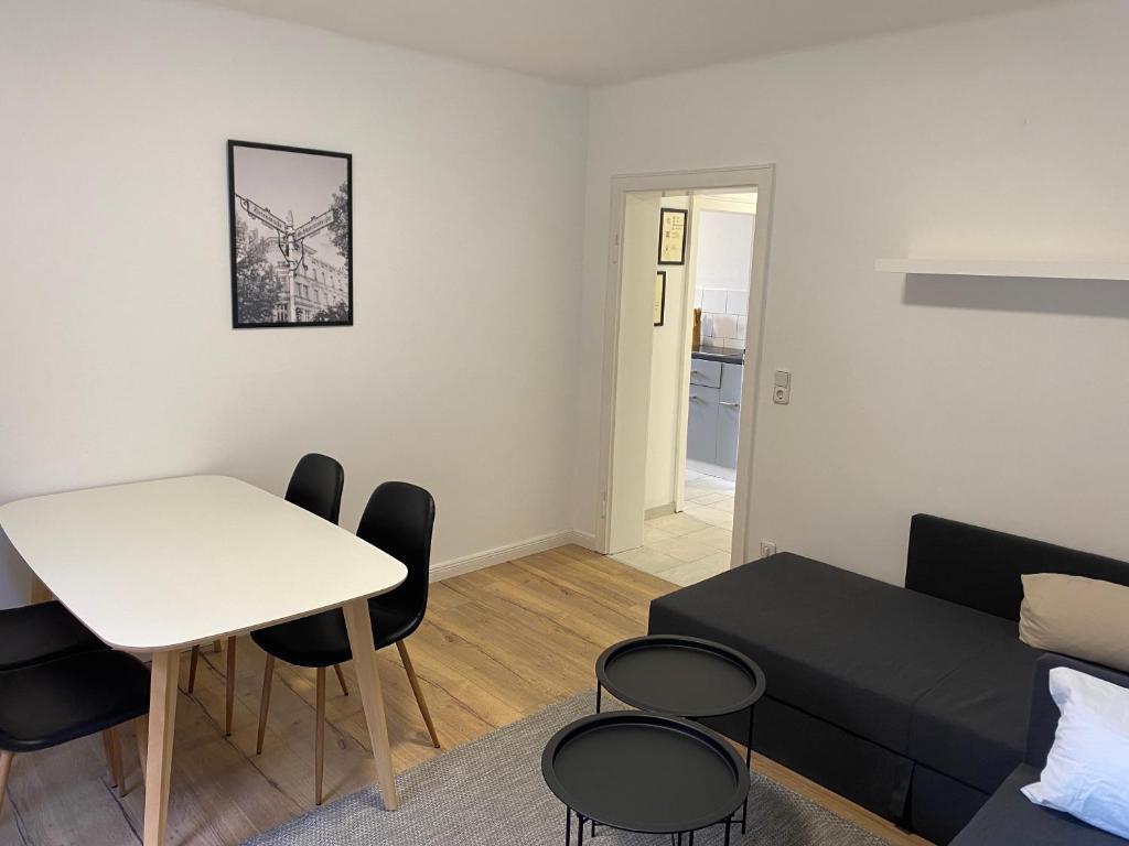 uma sala de estar com um sofá, uma mesa e cadeiras em 3 Zimmer City Apartment, TV, Netflix, WLAN, Free Parking em Bielefeld