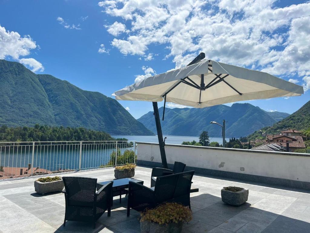 歐蘇西奧的住宿－La Terrazza Sul Lago，一个带桌子和遮阳伞的庭院