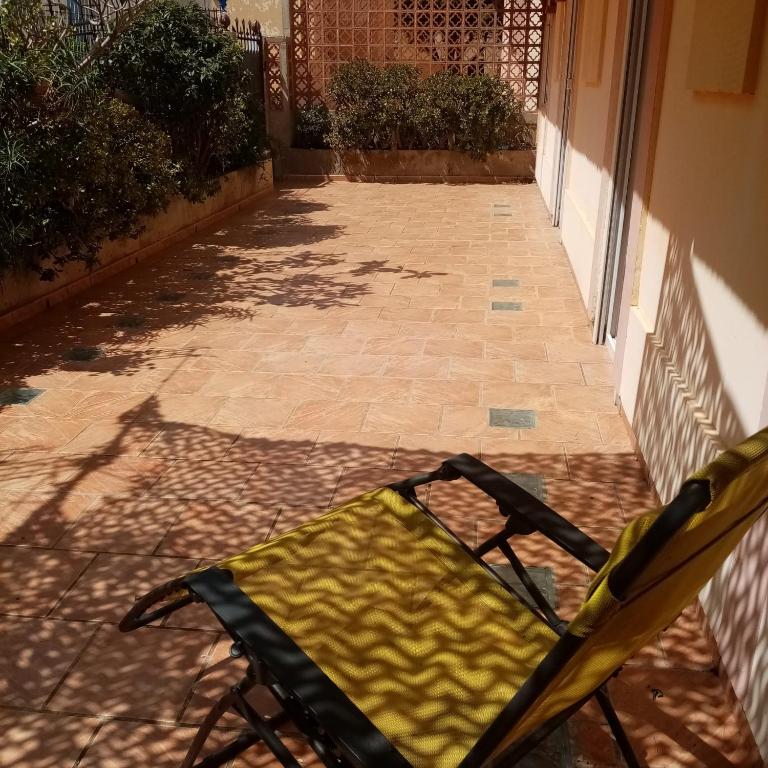 una silla plegable amarilla sentada en un patio en Studio avec terrasse en Cerbère