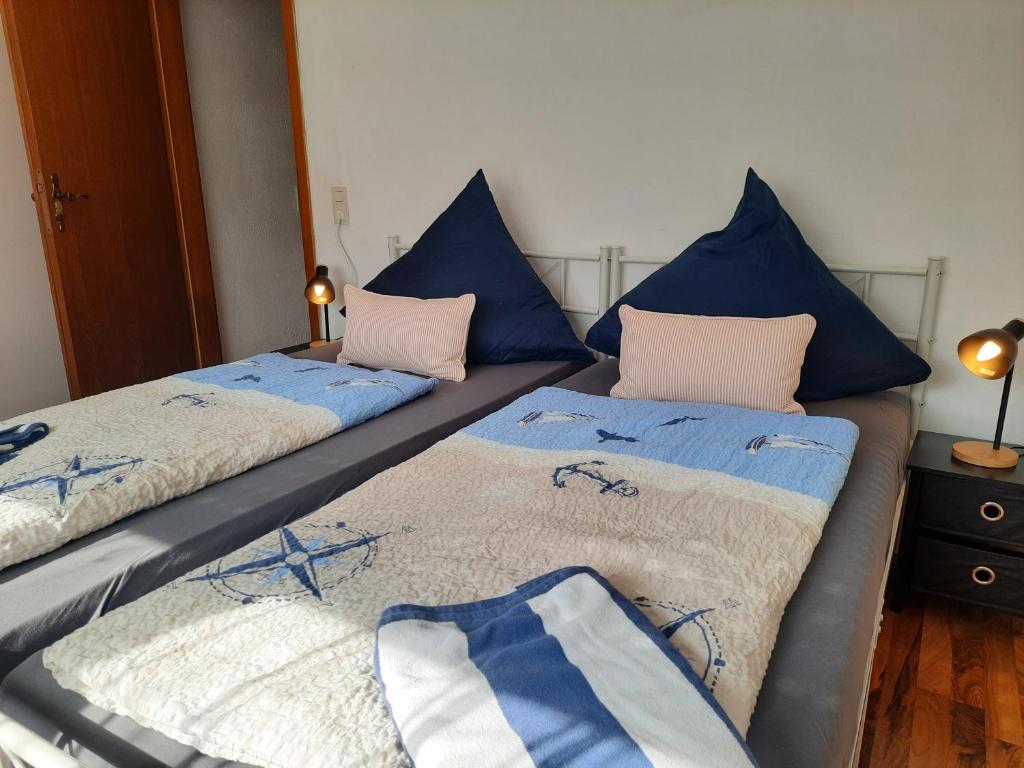 two beds in a room with blue pillows at Fewo klein aber fein 