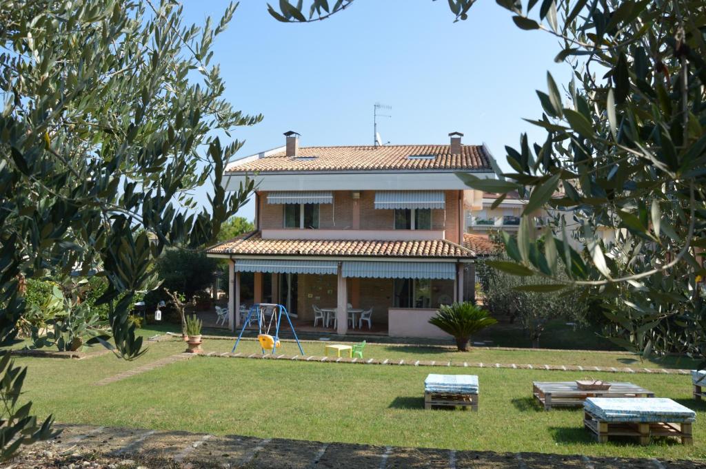 una casa grande con un patio con parque infantil en Casa Vacanza Villino dei Poeti en Pineto