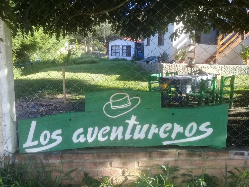 a green sign that reads los apartments at Los Aventureros in Samaipata