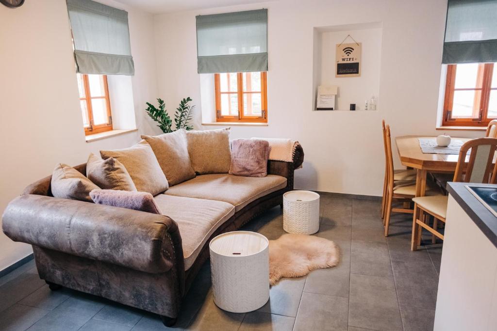 uma sala de estar com um sofá e uma mesa em Štekner house Apartma em Ljubno