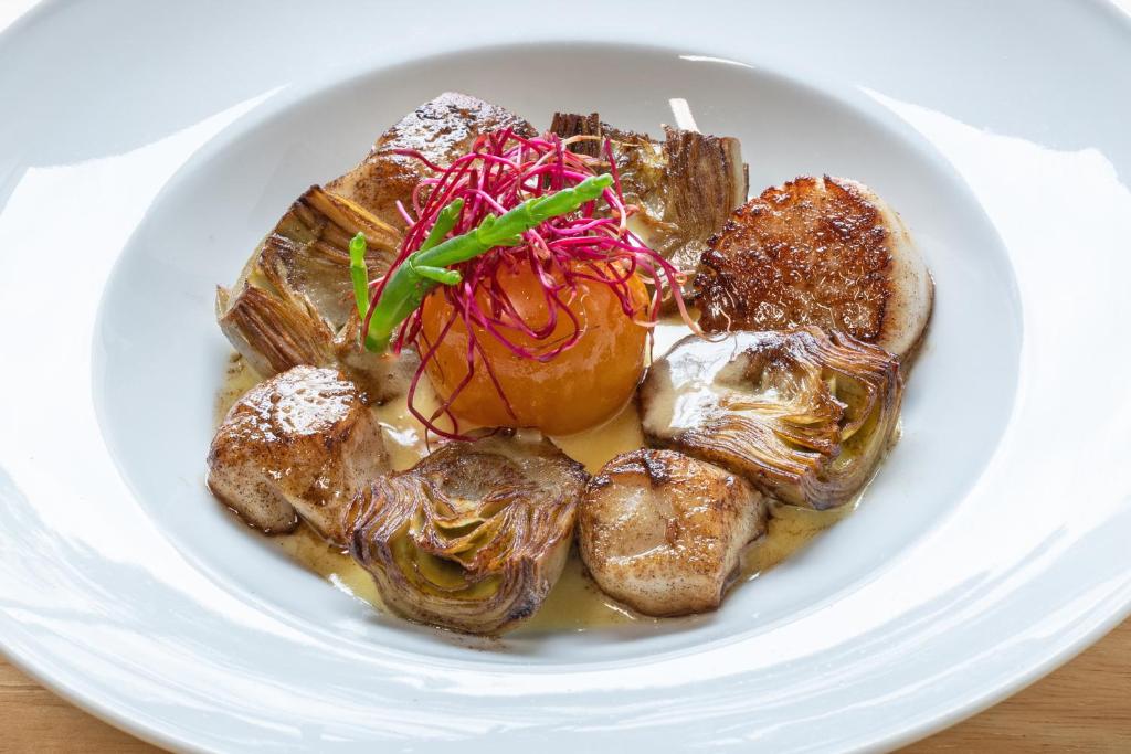 a white plate of food on a table at Le Theven in Sibiril