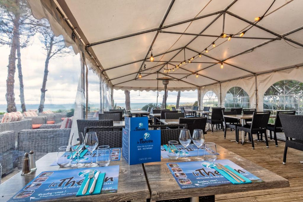 a tent with tables and chairs and wine glasses at Le Theven in Sibiril