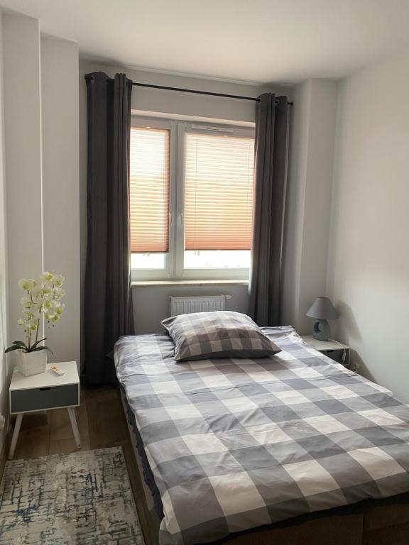 Schlafzimmer mit einem Bett und einem Fenster in der Unterkunft Apartament Daszyńskiego in Suwałki