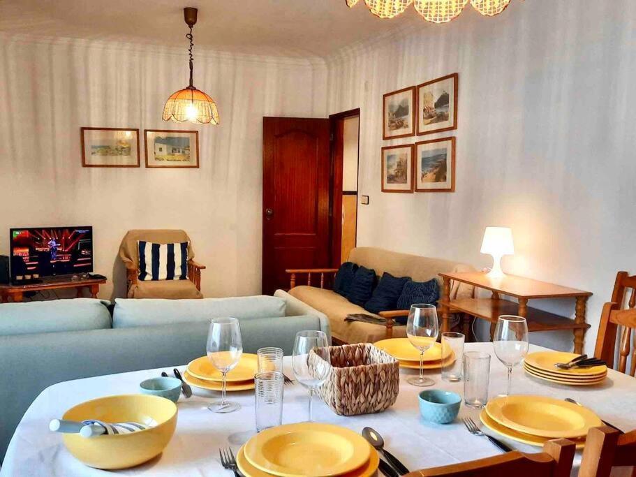 a living room with a table with plates and wine glasses at Golden wave in Ericeira