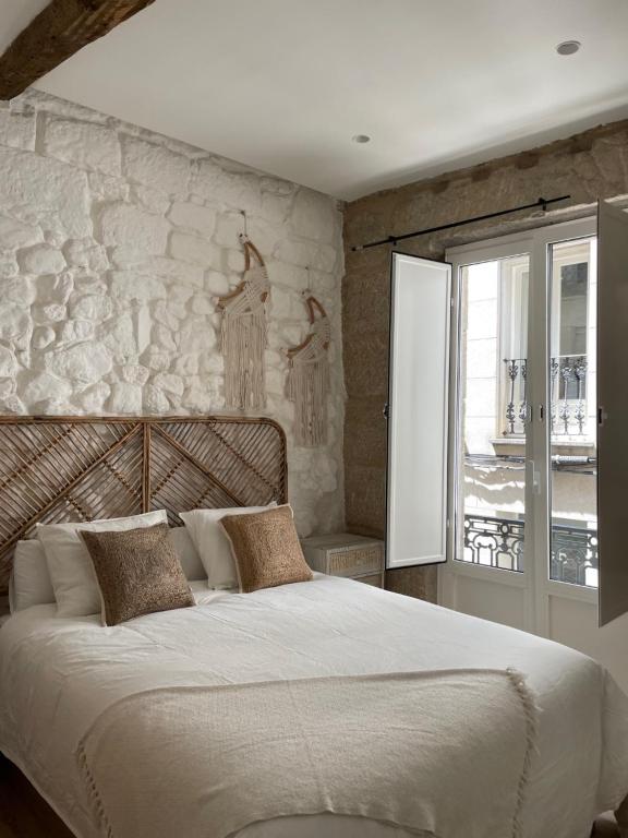 um quarto com uma cama grande e uma parede de pedra em A Das Marias VINTAGE em Ourense