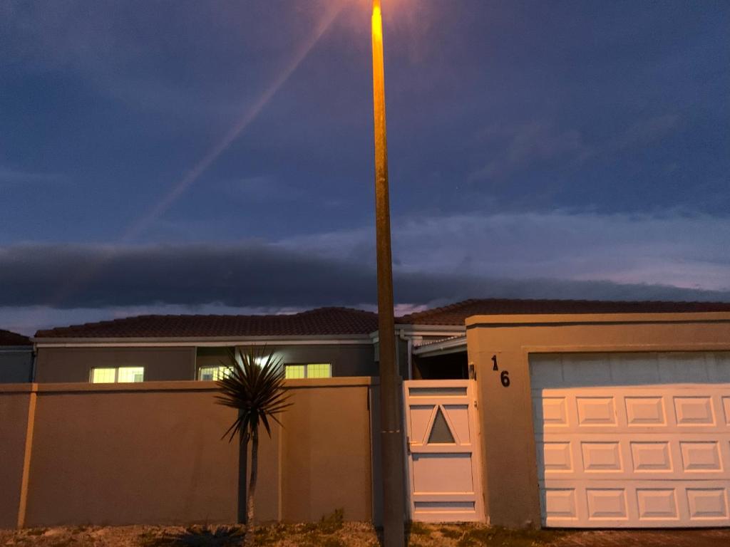a light pole next to a house with a garage at Naliya Guest house in Cape Town