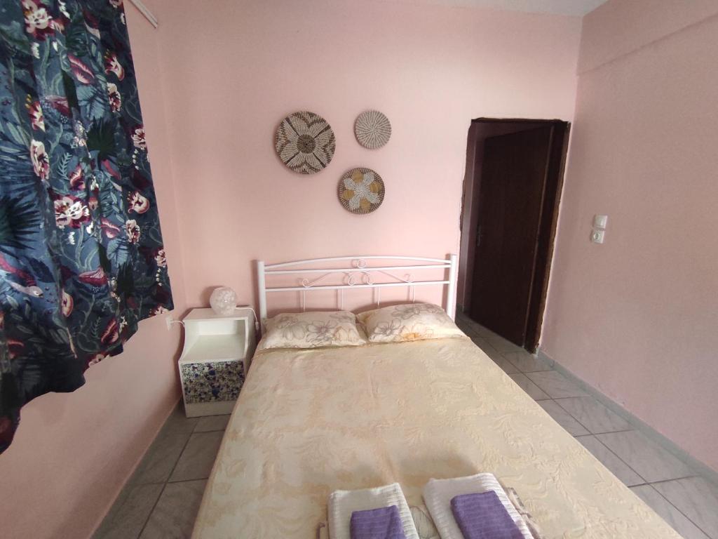Habitación pequeña con cama y reloj en la pared en Niki's house, en Agia Triada