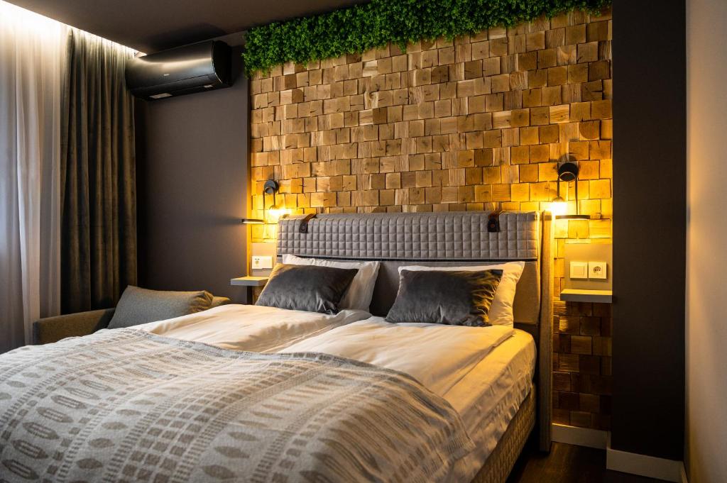 a bedroom with a large bed with a brick wall at Какао Апартамент Велинград in Velingrad