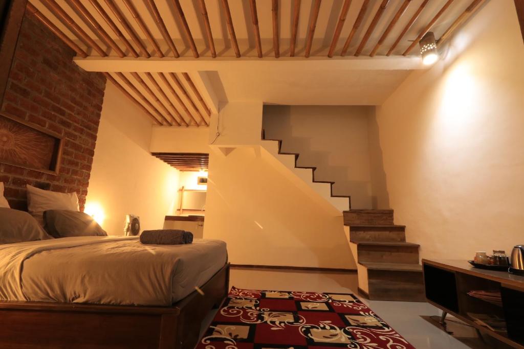 a bedroom with a bed and a staircase at Mu Homestay in Tetebatu
