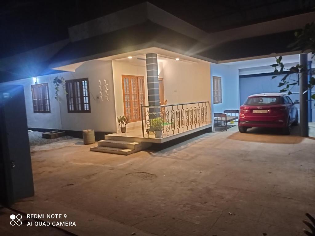 un coche aparcado delante de una casa por la noche en FAB HOUSE, en Thekkady
