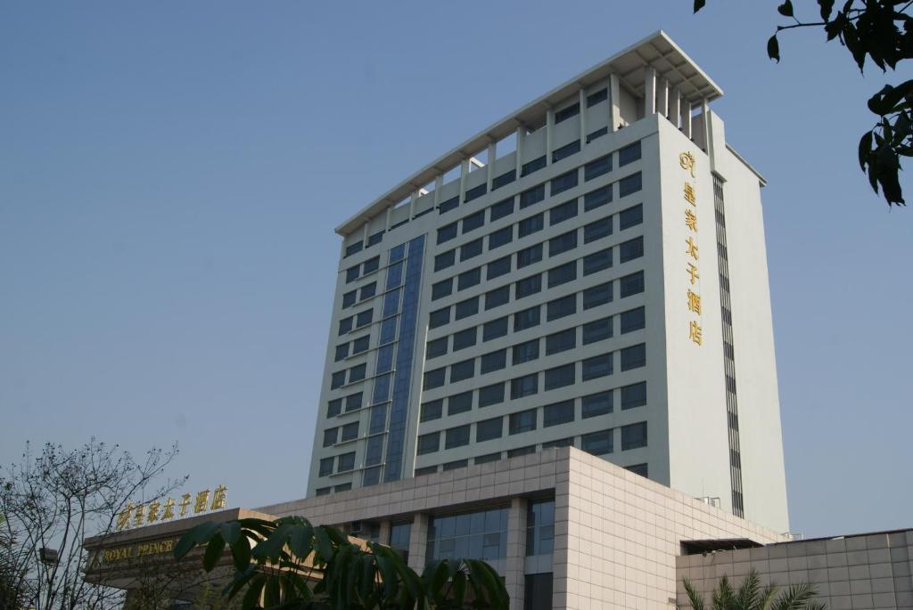 a tall white building with a clock on it at Foshan Royal Prince Hotel in Shunde