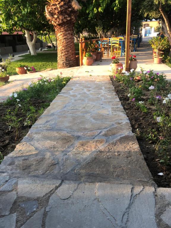a stone walkway in a park with flowers at Gregory's Village in Platy