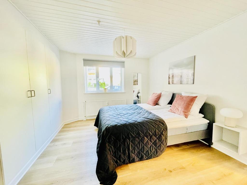 um quarto branco com uma cama e uma janela em aday - Charming apartment in the pedestrian street of Frederikshavn em Frederikshavn