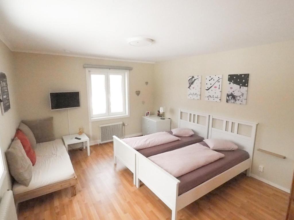 a bedroom with two beds and a couch at Linda's Apartment in Sörsjön