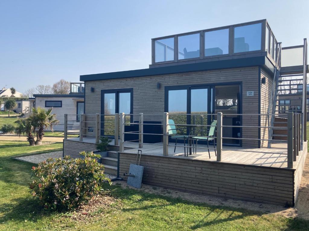 a house with a deck with a chair on it at Le Theven in Sibiril