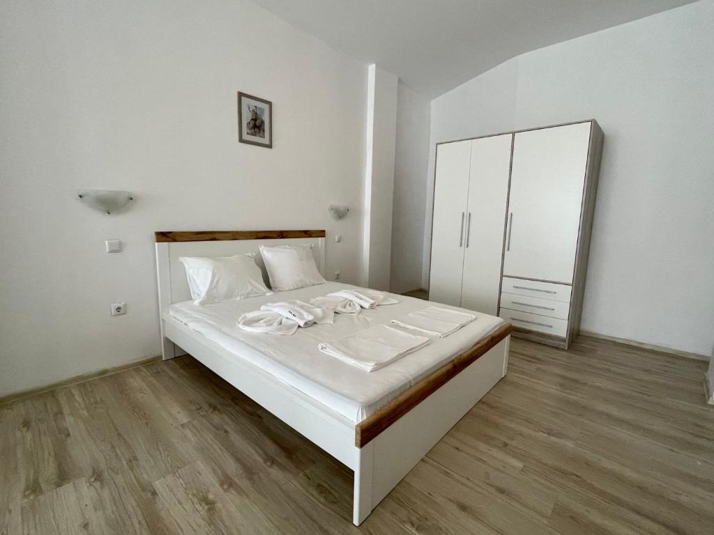 een witte slaapkamer met een bed en een spiegel bij Sveti Vlas - Central Beach Studio in Sveti Vlas