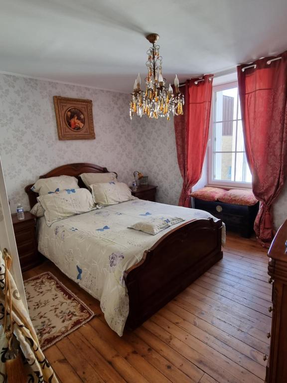 - une chambre avec un grand lit et un lustre dans l'établissement Breizh & Breakfast, à Rosporden
