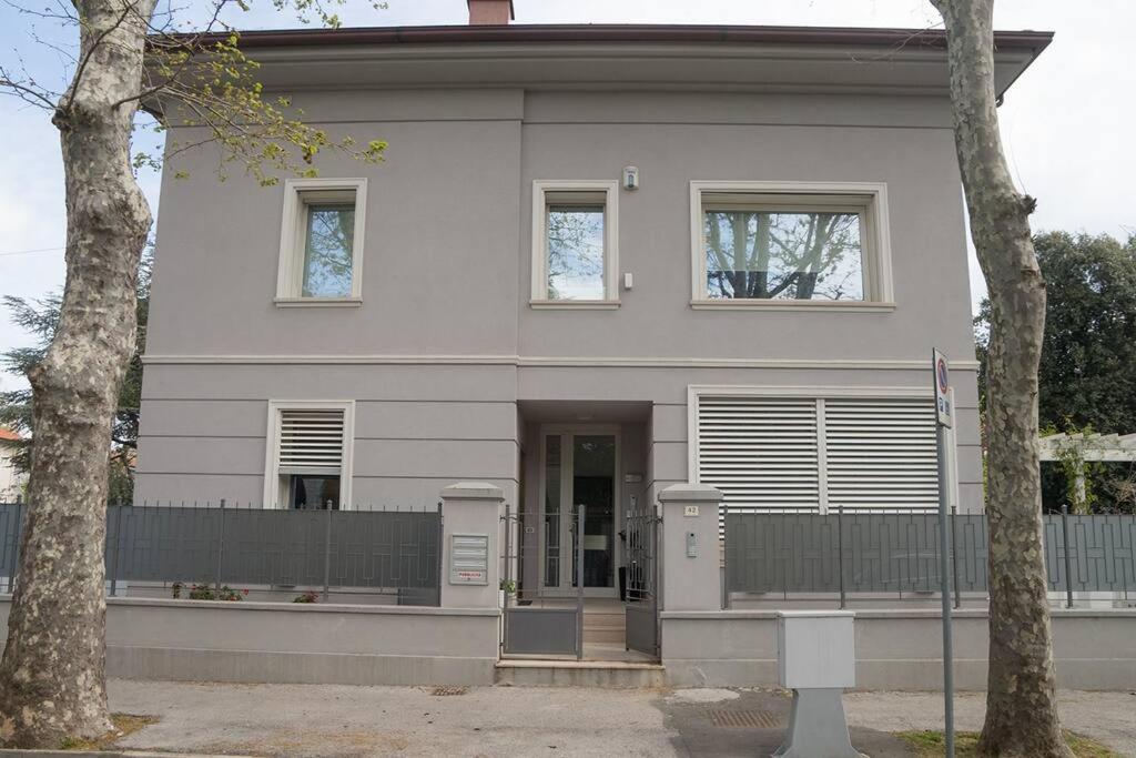 a white house with two windows and a fence at Appartamento al mare in Pesaro