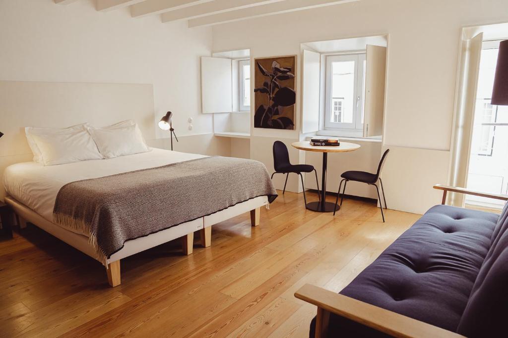 um quarto com uma cama, uma mesa e um sofá em The Late Birds Lisbon - Gay Urban Resort em Lisboa